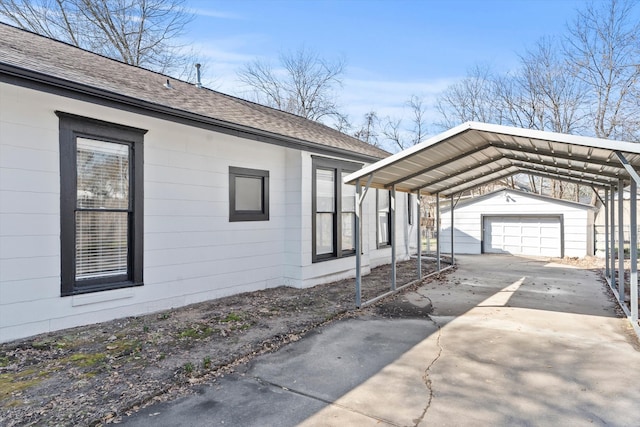 view of property exterior with an outbuilding, driveway, a shingled roof, and a carport