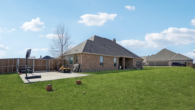 rear view of house featuring brick siding, a fenced backyard, a yard, and a patio