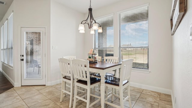 dining room featuring light tile patterned floors, baseboards, visible vents, and a notable chandelier