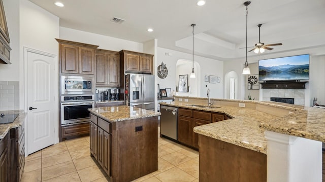 kitchen with a sink, visible vents, appliances with stainless steel finishes, a center island, and pendant lighting