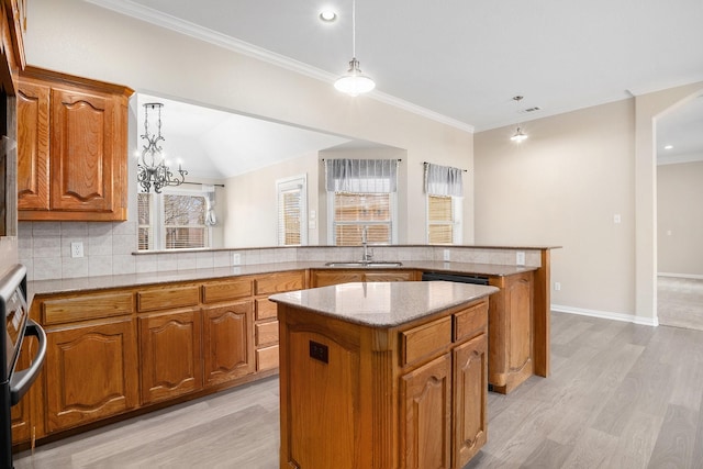 kitchen featuring a peninsula, a sink, a center island, brown cabinets, and decorative light fixtures