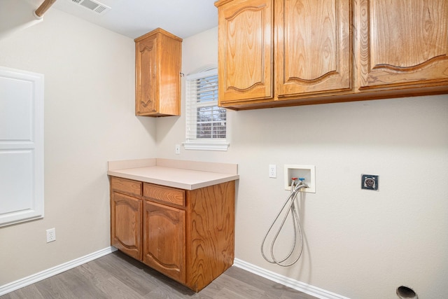 washroom with cabinet space, visible vents, dark wood-type flooring, hookup for a washing machine, and electric dryer hookup