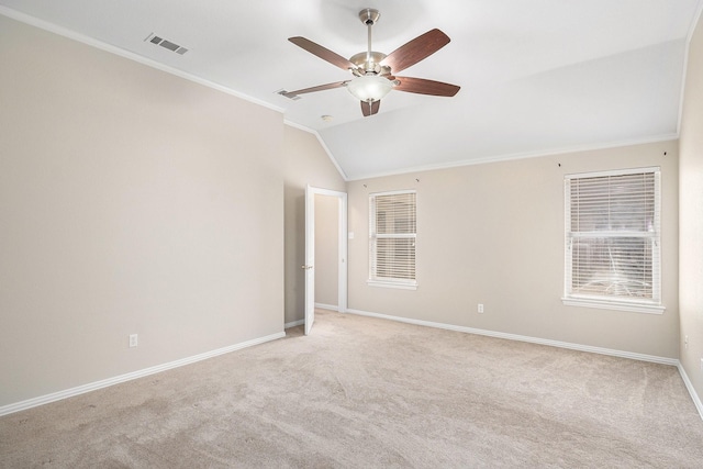 spare room featuring light carpet, baseboards, visible vents, ornamental molding, and vaulted ceiling