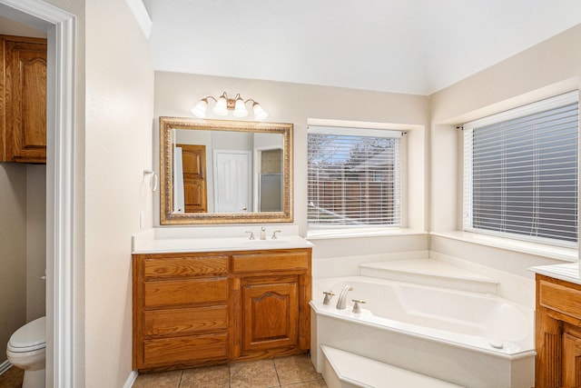 full bath featuring toilet, a garden tub, and vanity