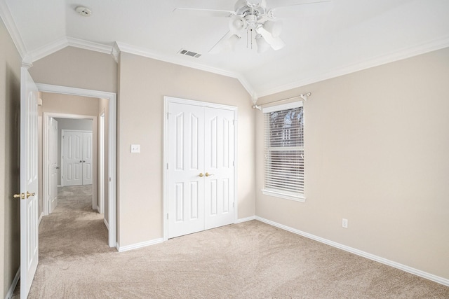 unfurnished bedroom with lofted ceiling, light carpet, visible vents, and crown molding