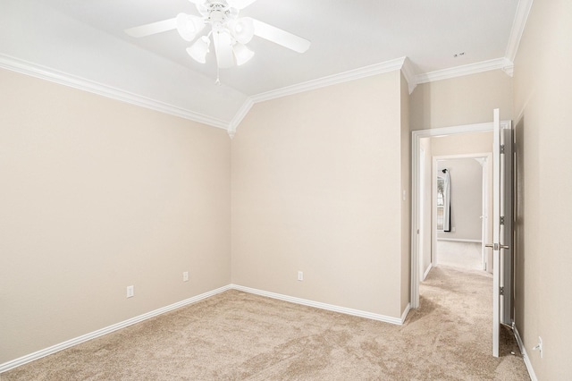 empty room featuring ornamental molding, light colored carpet, ceiling fan, and baseboards