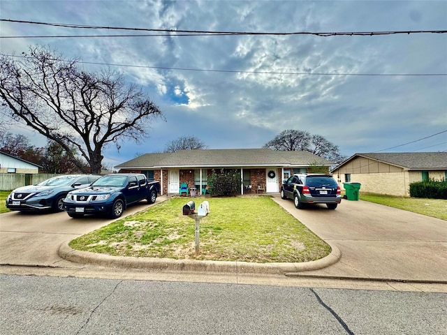 ranch-style home with concrete driveway, brick siding, and a front yard