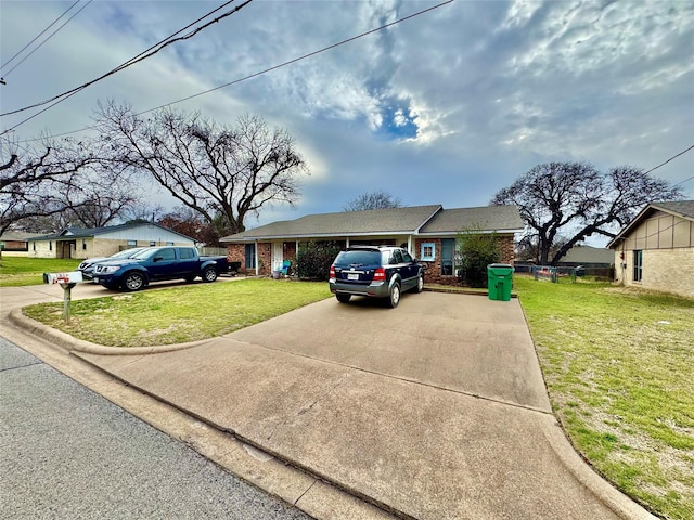 single story home with driveway, brick siding, and a front yard