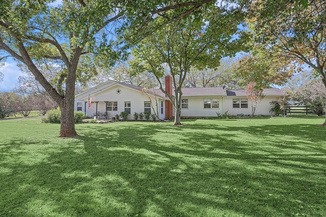 view of front of house featuring a front yard, fence, and a chimney