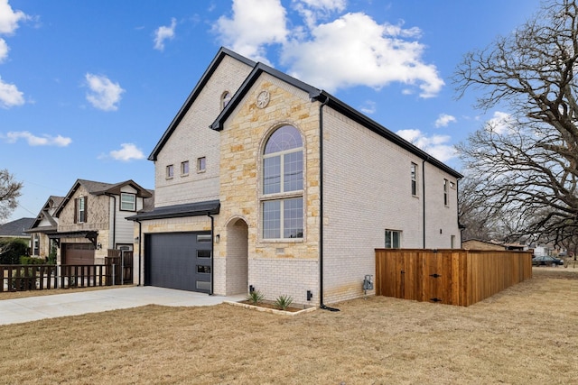 view of side of property featuring a garage, a yard, brick siding, and driveway