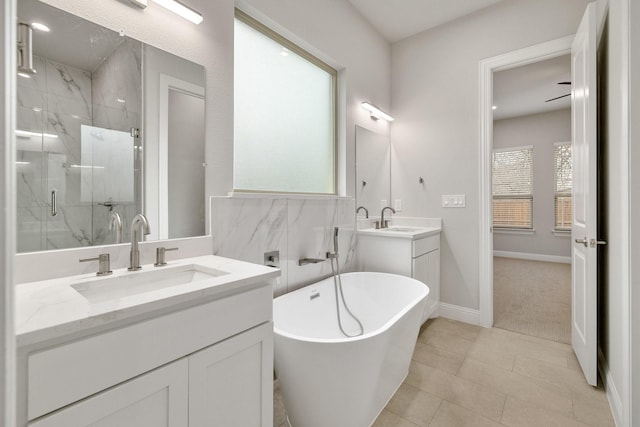 bathroom featuring a freestanding bath, two vanities, a sink, and a marble finish shower