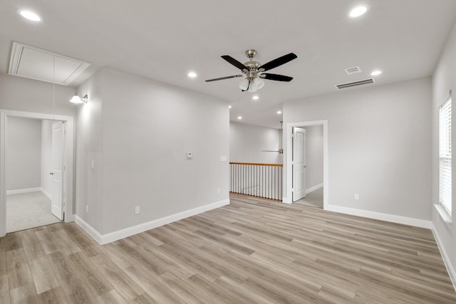 empty room with visible vents, light wood finished floors, attic access, and recessed lighting