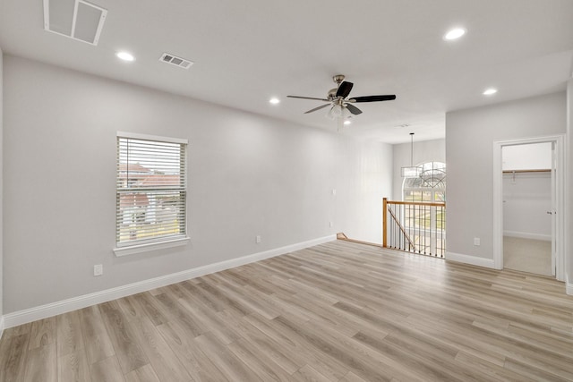 unfurnished room featuring baseboards, light wood-type flooring, visible vents, and recessed lighting