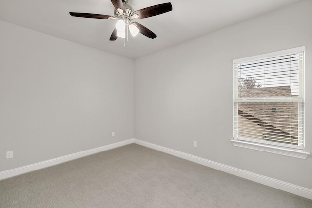 carpeted spare room with ceiling fan and baseboards