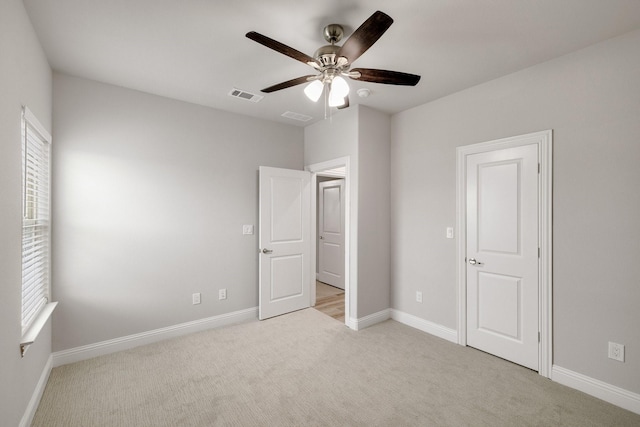 unfurnished bedroom with light carpet, ceiling fan, visible vents, and baseboards