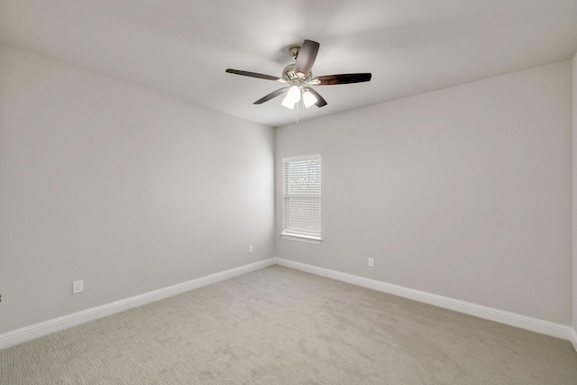 empty room featuring ceiling fan, baseboards, and light colored carpet