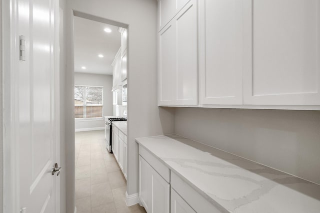 hallway featuring light tile patterned floors, baseboards, and recessed lighting