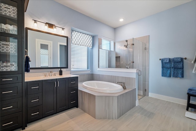 full bathroom with a stall shower, baseboards, and vanity