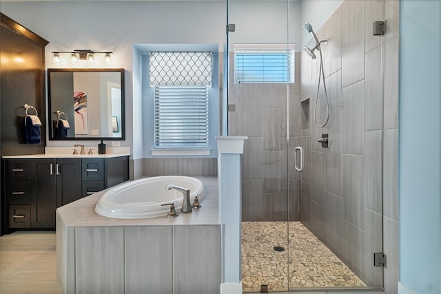 full bath featuring a shower stall, a bath, and vanity