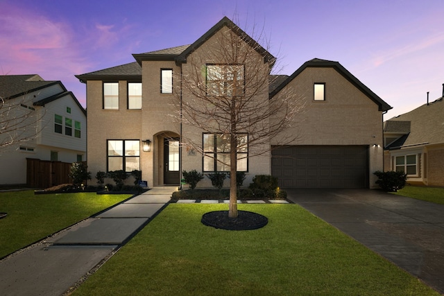 view of front of property featuring a garage, driveway, and a lawn