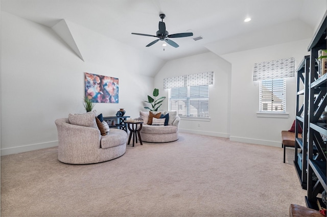 sitting room featuring lofted ceiling, baseboards, a ceiling fan, and light colored carpet