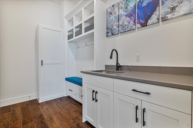 mudroom featuring dark wood-style floors, a sink, and baseboards