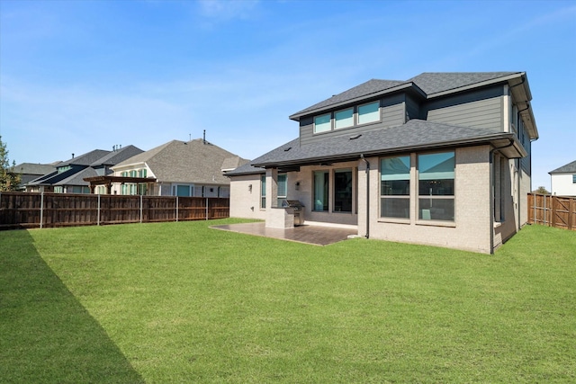 rear view of property featuring a patio area, a fenced backyard, a yard, and brick siding