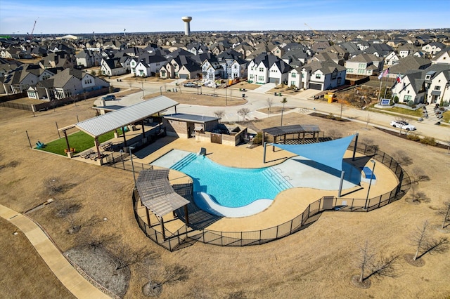 community pool featuring a residential view, a patio area, and fence