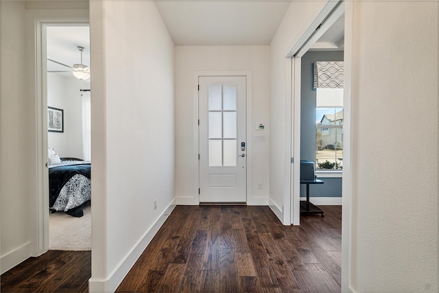 doorway to outside with dark wood-type flooring and baseboards