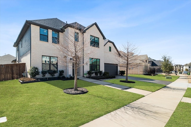 view of front of home featuring a front yard, fence, driveway, and an attached garage