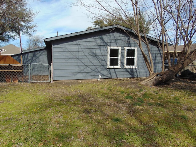 view of property exterior with a gate, fence, and a yard