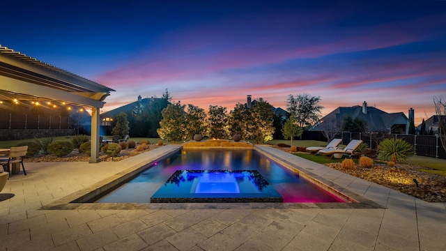 pool at dusk with a patio, a fenced backyard, and a fenced in pool