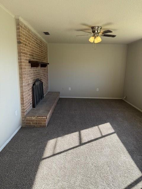 unfurnished living room with visible vents, baseboards, a textured ceiling, a brick fireplace, and dark carpet