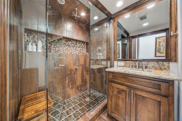 bathroom with a shower stall, visible vents, and vanity