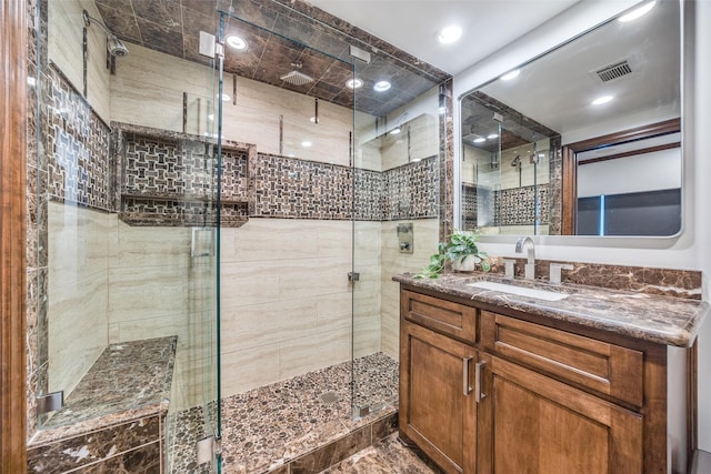 bathroom featuring vanity, a shower stall, and visible vents