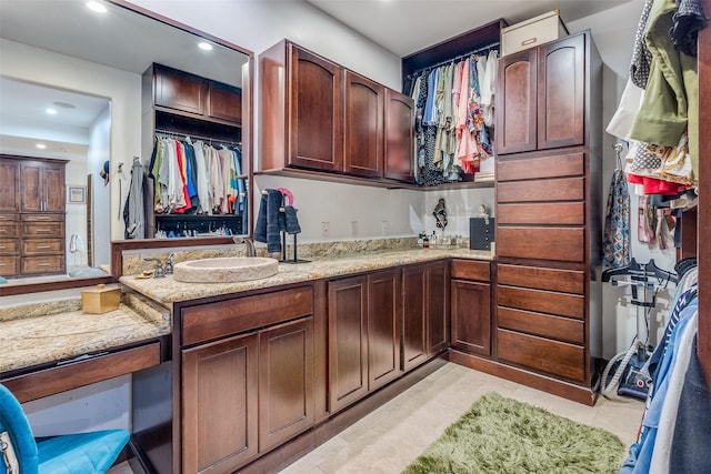 kitchen with recessed lighting, a sink, and light stone countertops