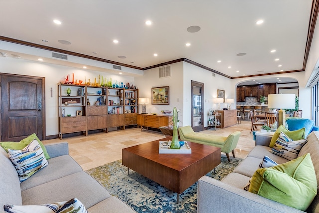 living area with baseboards, ornamental molding, visible vents, and recessed lighting