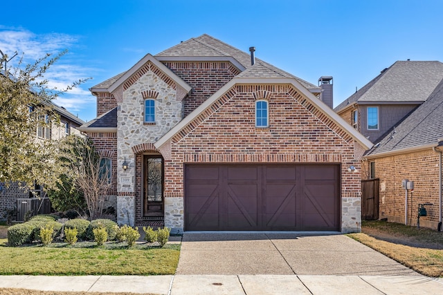 french provincial home with driveway, a shingled roof, stone siding, an attached garage, and brick siding