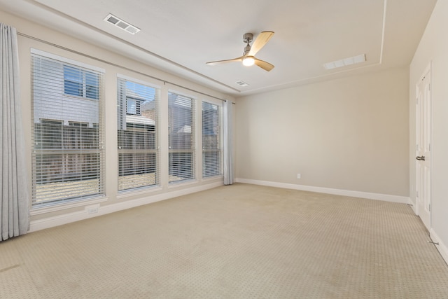 unfurnished room featuring light carpet, baseboards, visible vents, and a ceiling fan