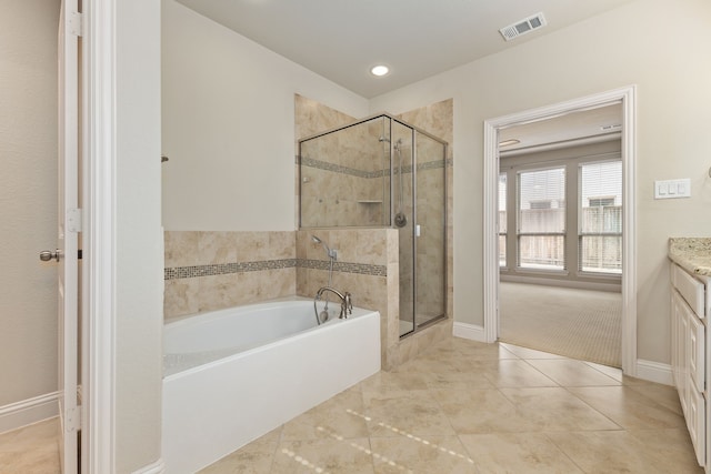 bathroom featuring a stall shower, baseboards, visible vents, a garden tub, and vanity