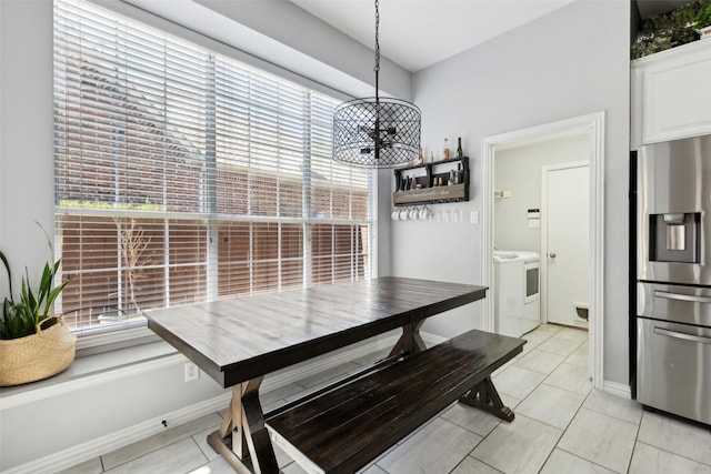 dining area with light tile patterned floors, plenty of natural light, and washing machine and clothes dryer