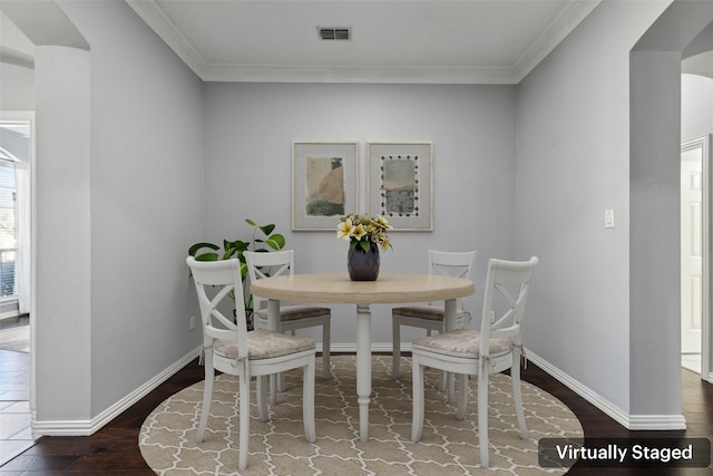 dining room with ornamental molding, visible vents, dark wood finished floors, and baseboards