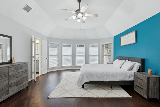 bedroom with baseboards, visible vents, a raised ceiling, ceiling fan, and dark wood-style flooring