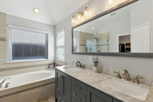 bathroom featuring vaulted ceiling, double vanity, a sink, and a bath