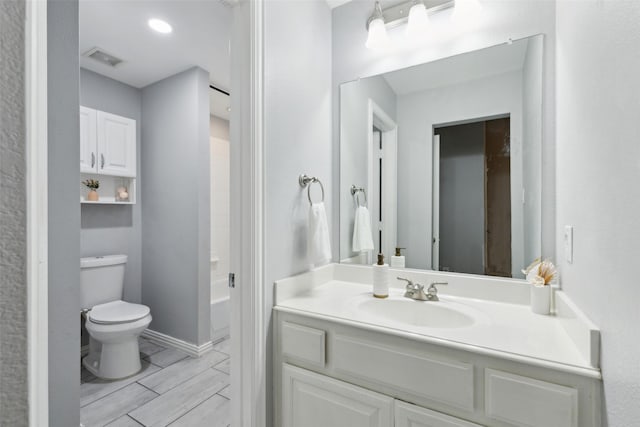 full bathroom featuring toilet, vanity, baseboards, visible vents, and wood tiled floor