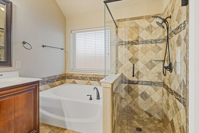 full bathroom with a shower stall, a bath, and vanity