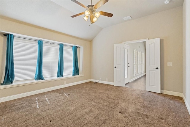 spare room with lofted ceiling, carpet flooring, visible vents, and baseboards