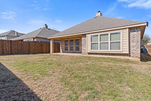 rear view of property with a shingled roof, a lawn, fence, central air condition unit, and brick siding