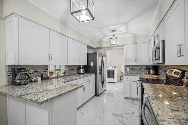 kitchen featuring stainless steel appliances, hanging light fixtures, washer / dryer, and white cabinets