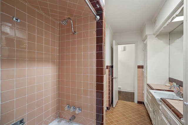 full bathroom with tile patterned flooring, vanity, tile walls, and shower / bathtub combination